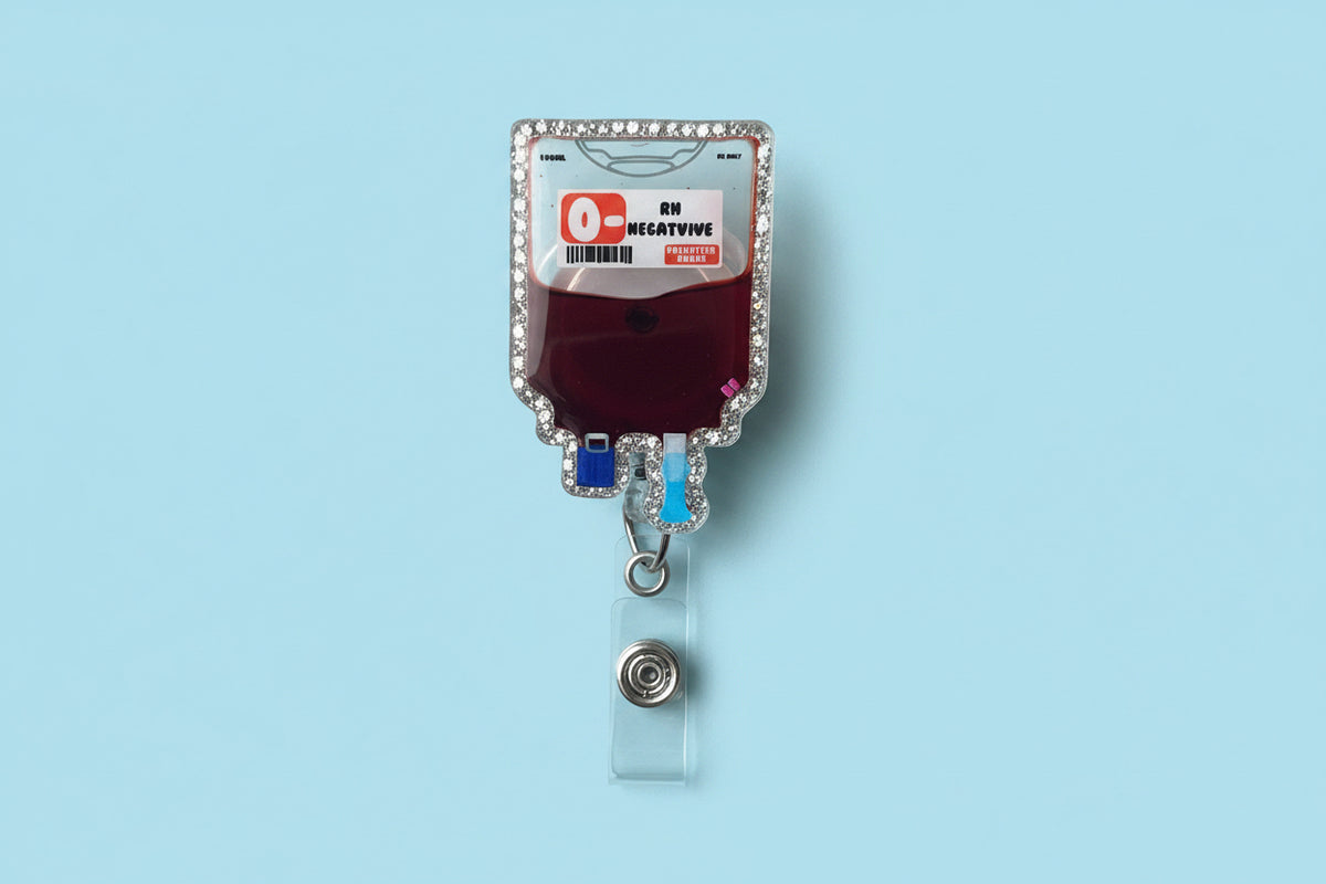 Hand holding a decorative blood bag with a '0- Negative' label against a neutral background