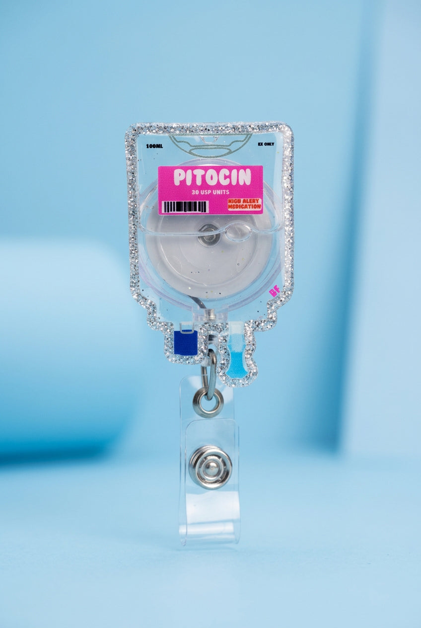 Hand holding a decorative badge reel with 'Pitocin' label on a plain background