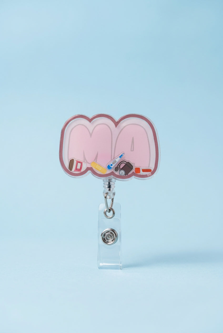 MA shaker badge reel with pale pink lettering, a rose border, and miniature coffee cup, bandage, thermometer, blood pressure cuff, and specimen tube.

