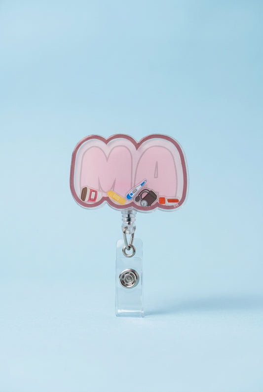 MA shaker badge reel with pale pink lettering, a rose border, and miniature coffee cup, bandage, thermometer, blood pressure cuff, and specimen tube.
