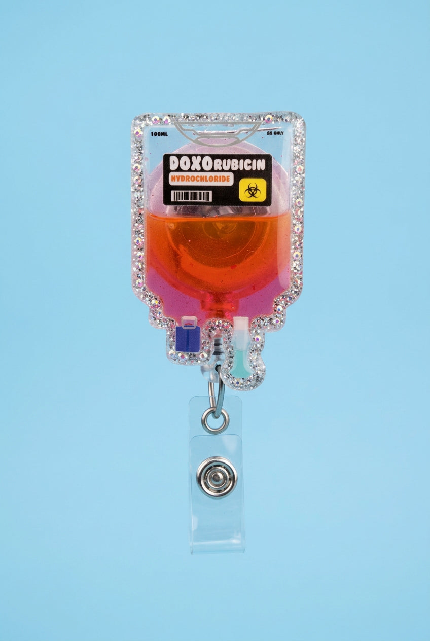 A pink-gloved hand holds a rhinestone-embellished IV bag labeled 'DOXORUBICIN HYDROCHLORIDE' filled with pink liquid, set against a blurred outdoor wooden deck background.