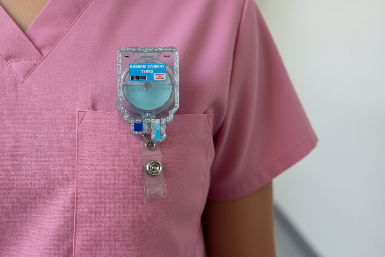 Hand holding a badge reel with 'Nursing Student Tears' text against a plain background