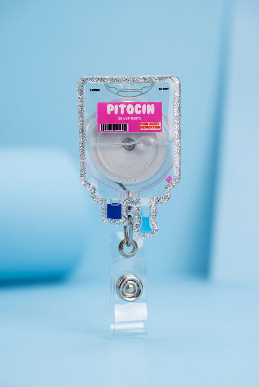 Hand holding a decorative badge reel with 'Pitocin' label on a plain background